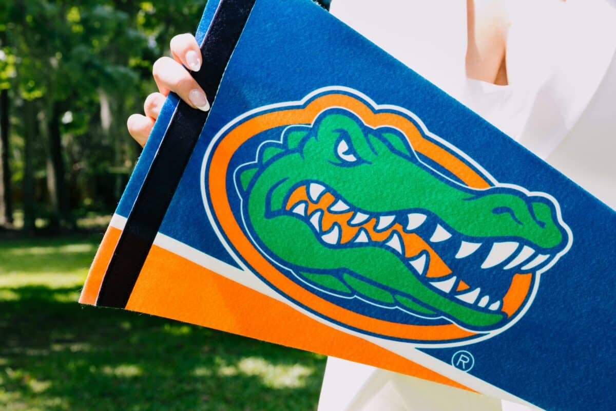 Hand holding Florida Gators team banner symbolizing team spirit and sports enthusiasm outdoors.